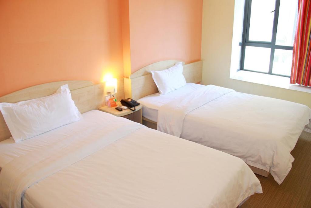 东莞7天连锁酒店东莞厚街会展中心店的酒店客房设有两张床和窗户。