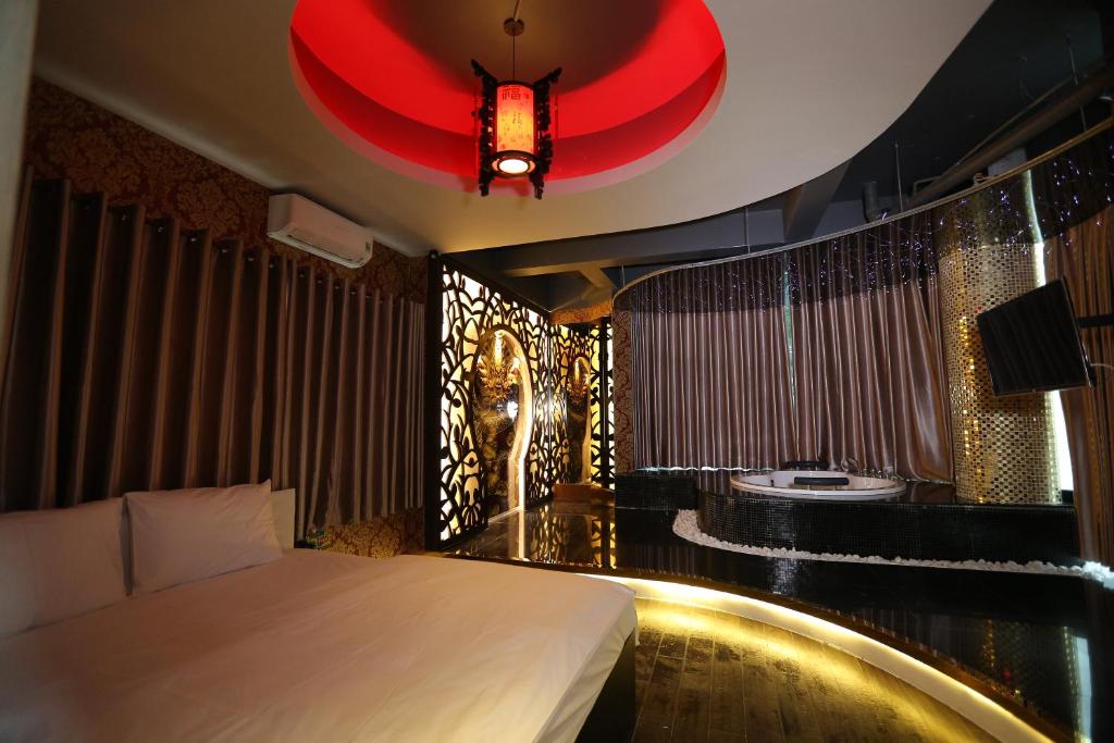 胡志明市博尼塔大酒店的酒店客房,配有一张床和红色吊灯