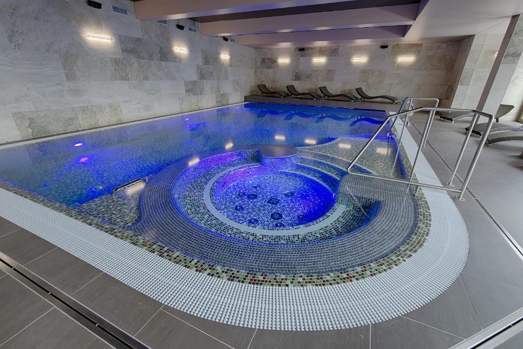 阿贝尔塔米奥里昂旅馆的大楼内带蓝色浴缸的大型游泳池