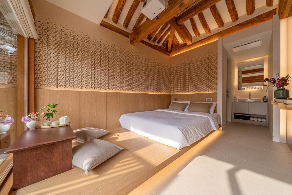首尔Seoul Premium Hanok MemoryStay Hyoja的卧室配有一张床铺,位于带桌子的房间