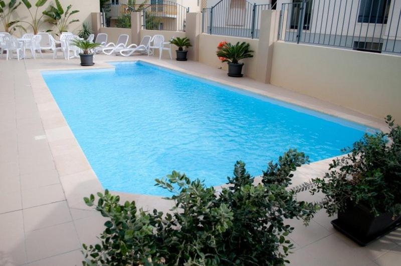 San Ġwann卡帕拉酒店的一座建筑物中央的游泳池