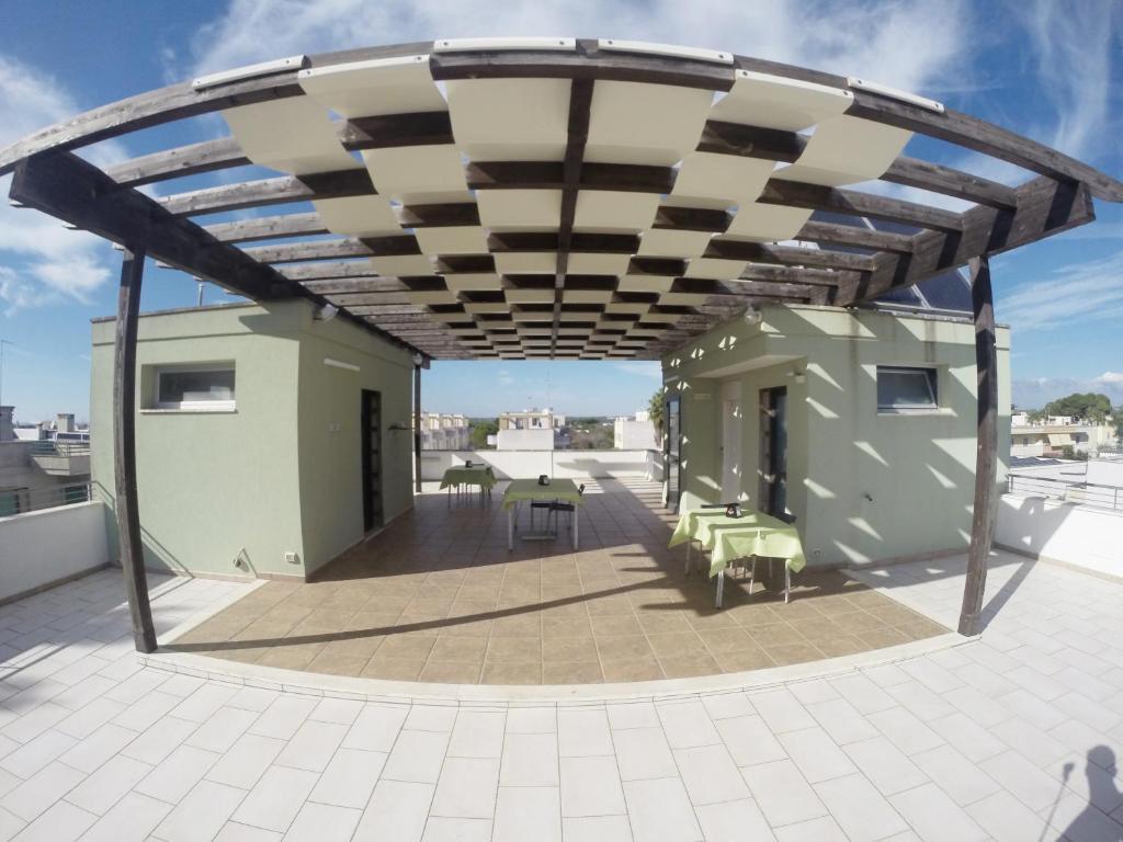 阿莱齐奥加利波利大道住宿加早餐酒店的屋顶甲板设有遮阳篷和桌椅