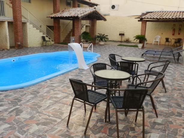 帕尔马斯Hotel Estrela Palmas的游泳池旁带桌椅的天井