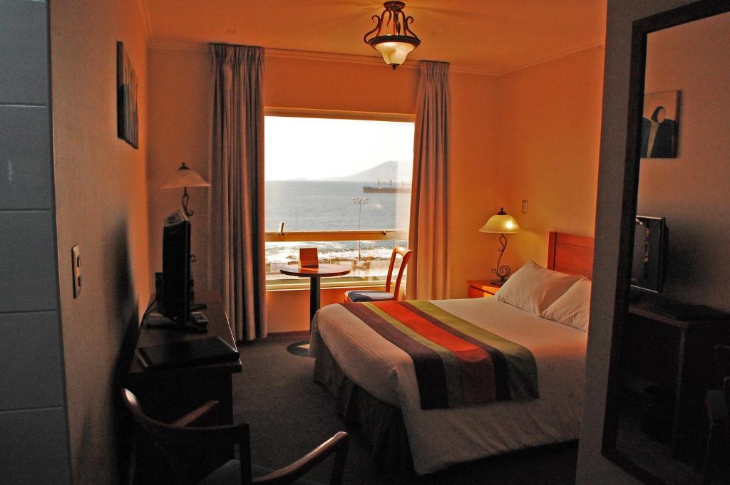 安托法加斯塔佛罗伦萨套房公寓酒店的酒店客房设有一张床,享有海景。