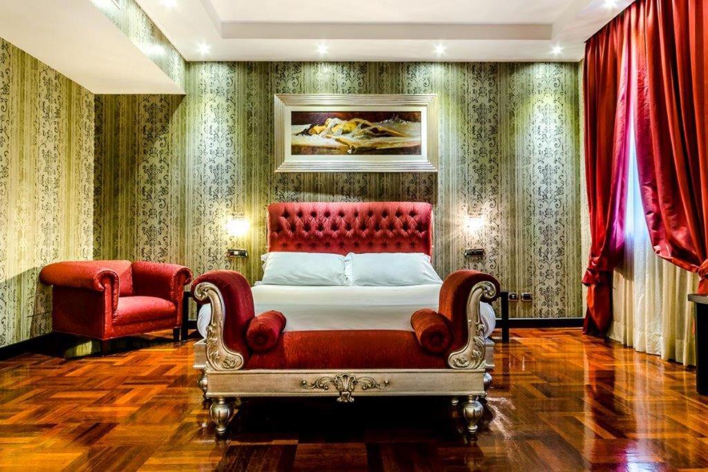 米兰Hotel Silver Milano的一间卧室配有红色的床和红色椅子