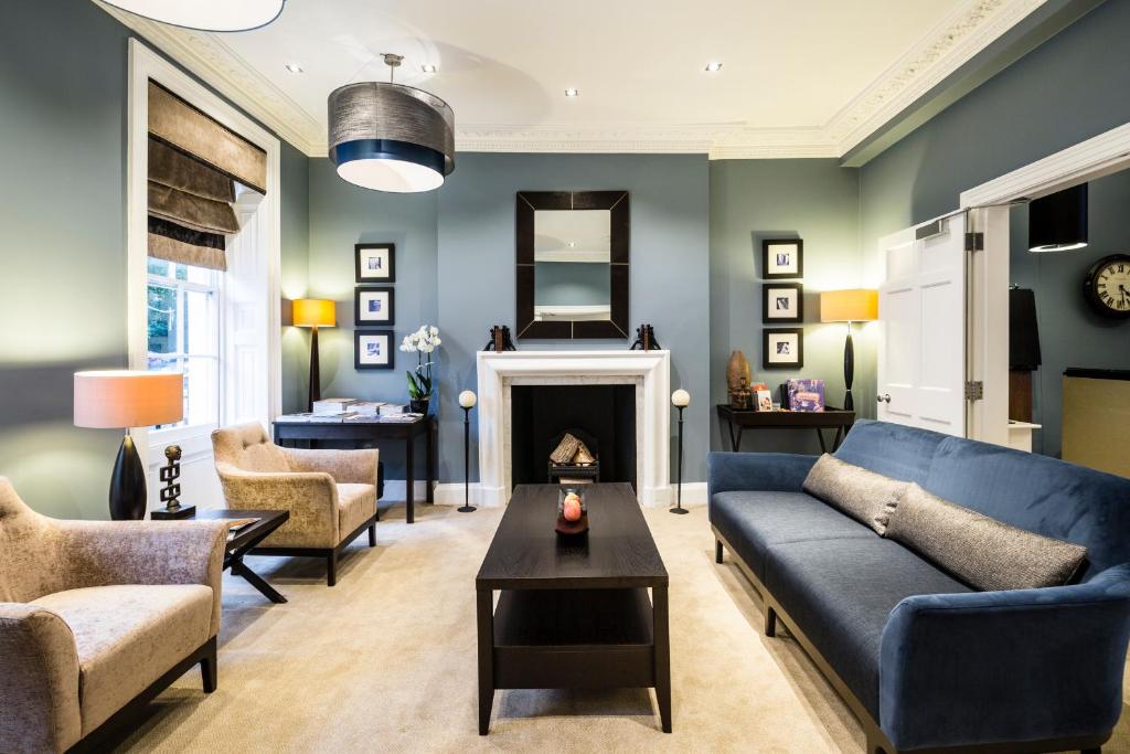 伦敦蒙塔古广场酒店的客厅设有蓝色的沙发和壁炉