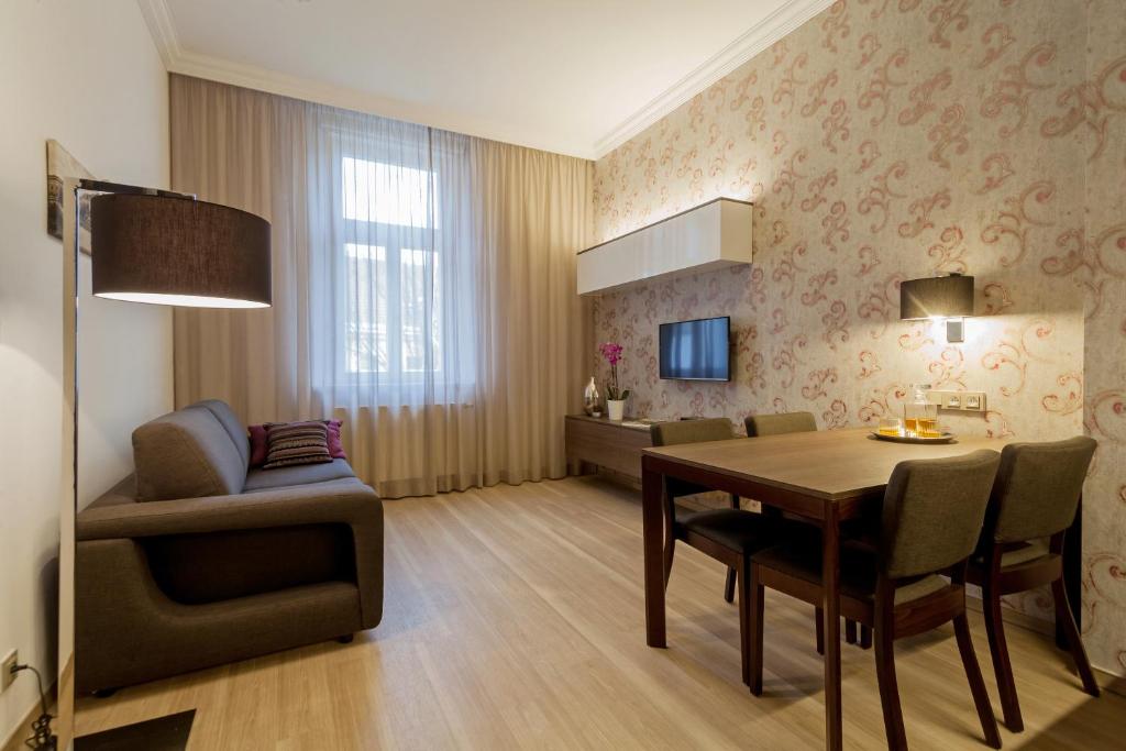 布拉格VINOHRADSKY DUM Residence的一间带桌椅的客厅和一间餐厅