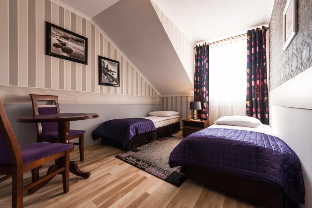 卢布林Noclegi Komfort的一间卧室设有两张床、一张桌子和一个窗口