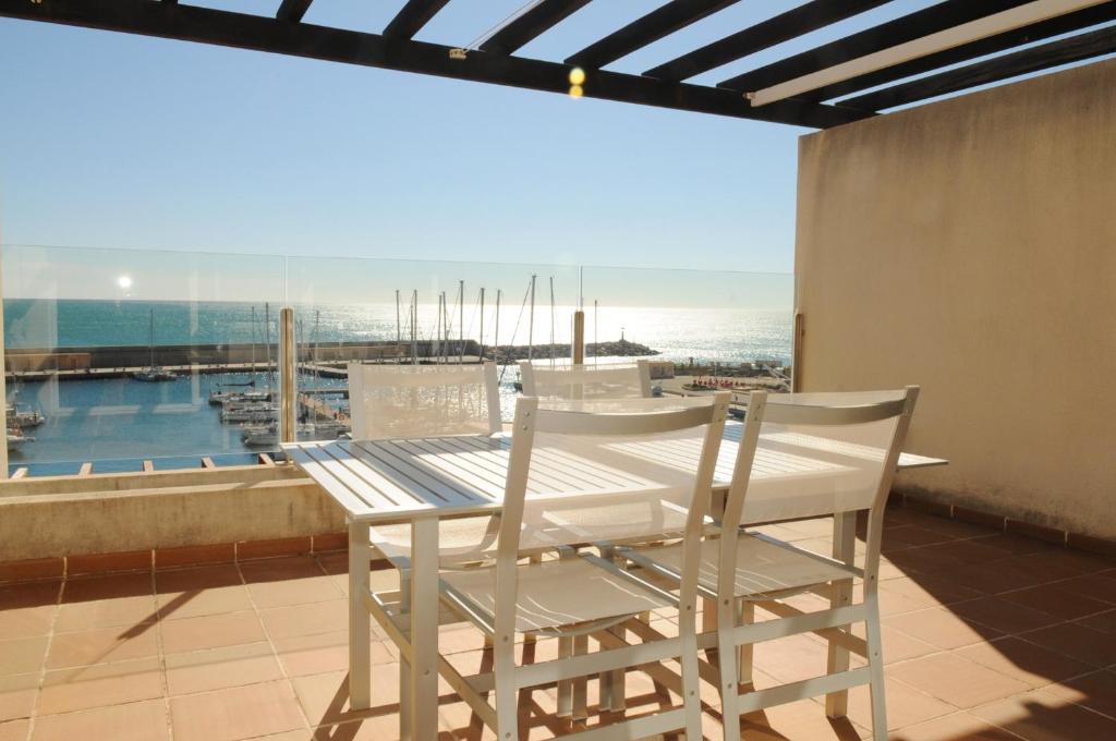 拉梅特拉·德·玛尔Residencial Marina de Port的海景阳台上的桌椅