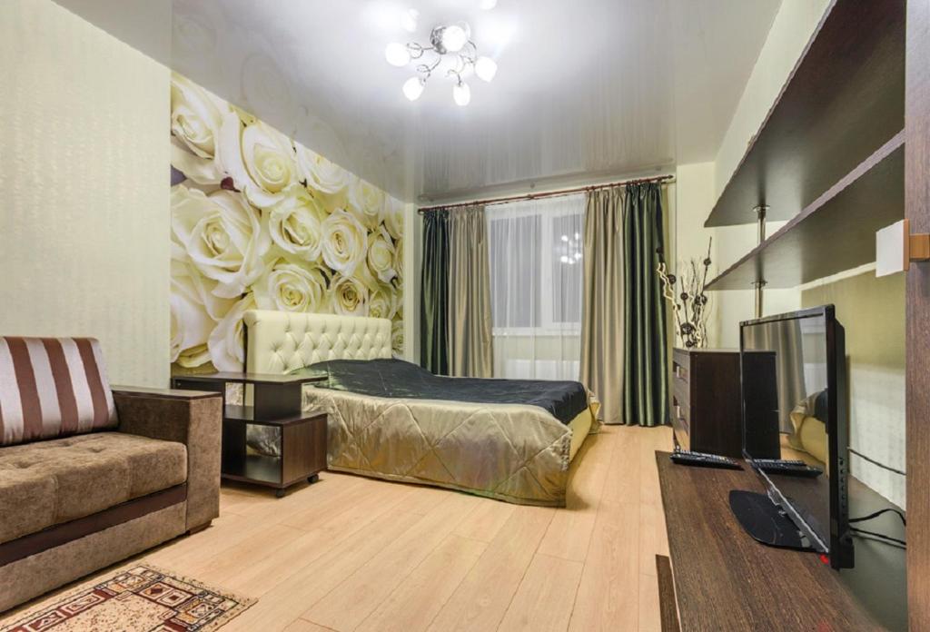 沃罗涅什ATLANT Apartments 106的一间卧室配有一张床、一张沙发和一台电视。