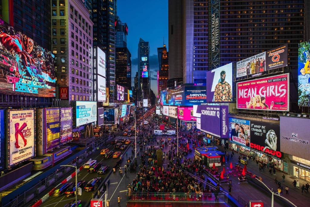 纽约Renaissance New York Times Square by Marriott的城市繁忙的街道,晚上有广告牌