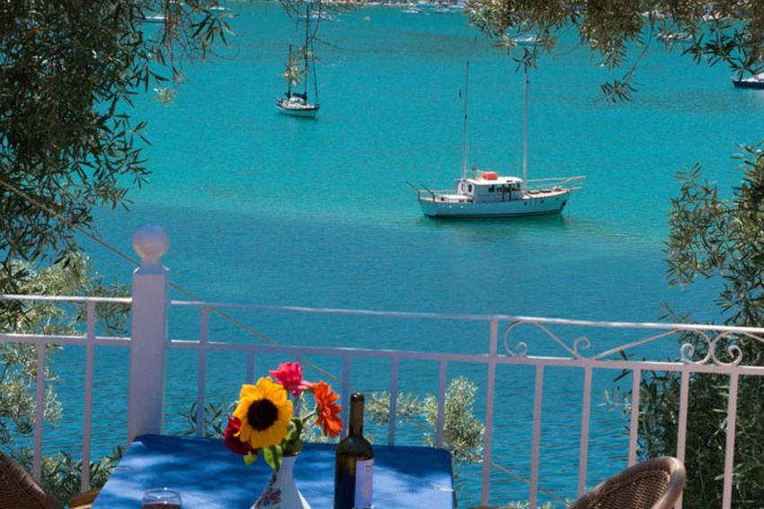 耶尼翁Ilios Hotel & Villas的桌子上放着一瓶葡萄酒,水里放着一条船