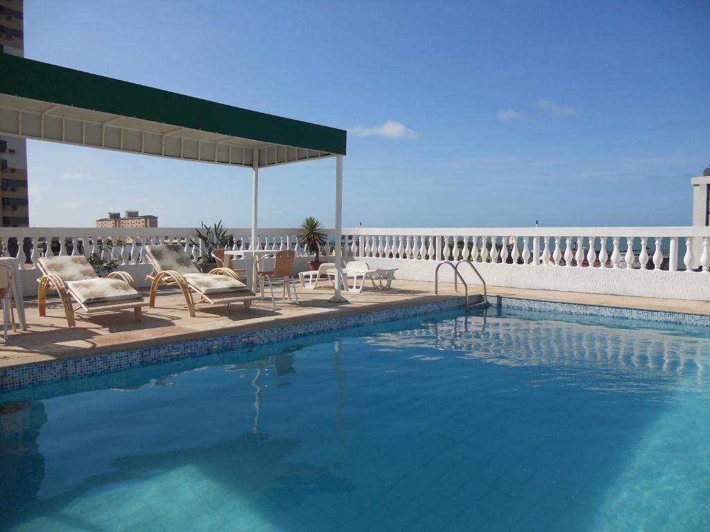 福塔莱萨阿尔加维海滩公寓的一座带桌椅的游泳池以及一座建筑