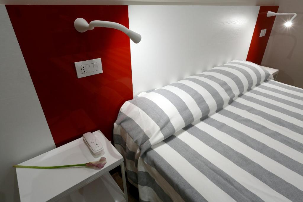 里米尼金叶酒店 的配有床和台灯的桌子的房间