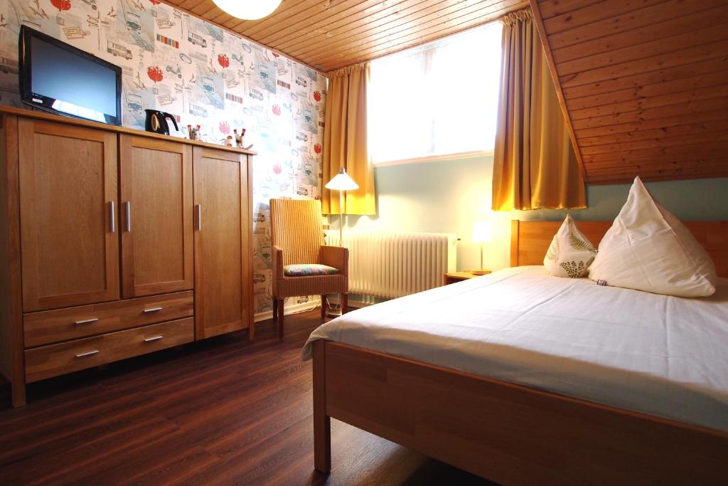 不莱梅布莱梅伽斯特豪斯酒店的卧室配有一张床,墙上配有电视。