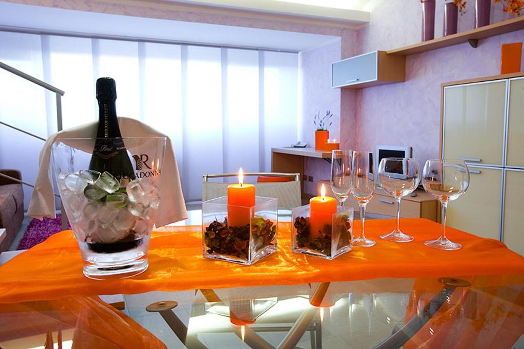 维泰博Le Onde Resort的一张桌子,上面放着眼镜,还有一瓶葡萄酒和蜡烛