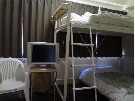 名古屋名古屋生态酒店的一间卧室配有双层床,书桌上配有电脑