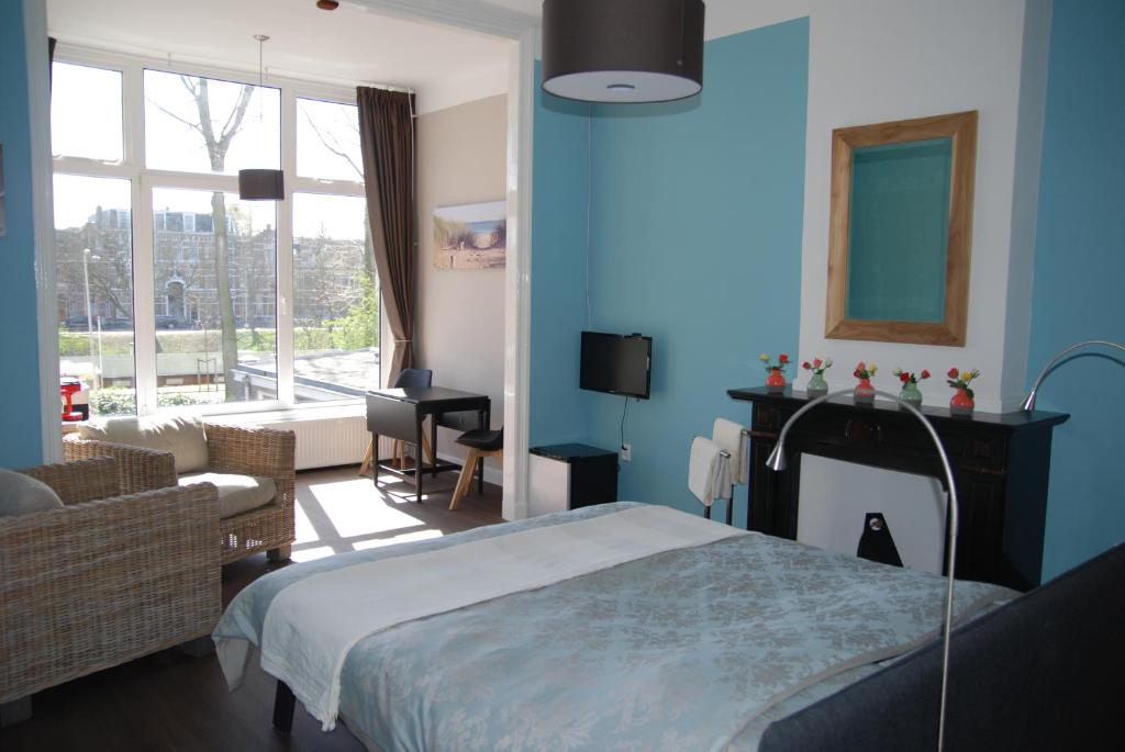 海牙欧泊里齐特斯特拉特住宿加早餐旅馆的一间蓝色的卧室,配有床和客厅