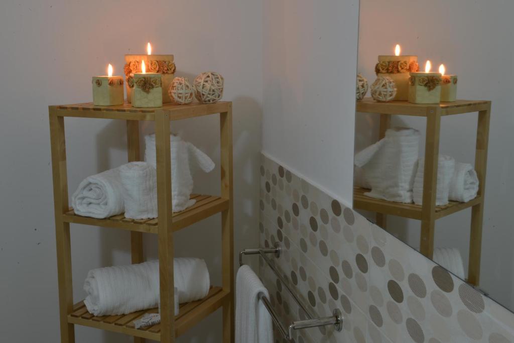 马泰拉Il Nespolo Matera的浴室设有2个带蜡烛和毛巾的架子