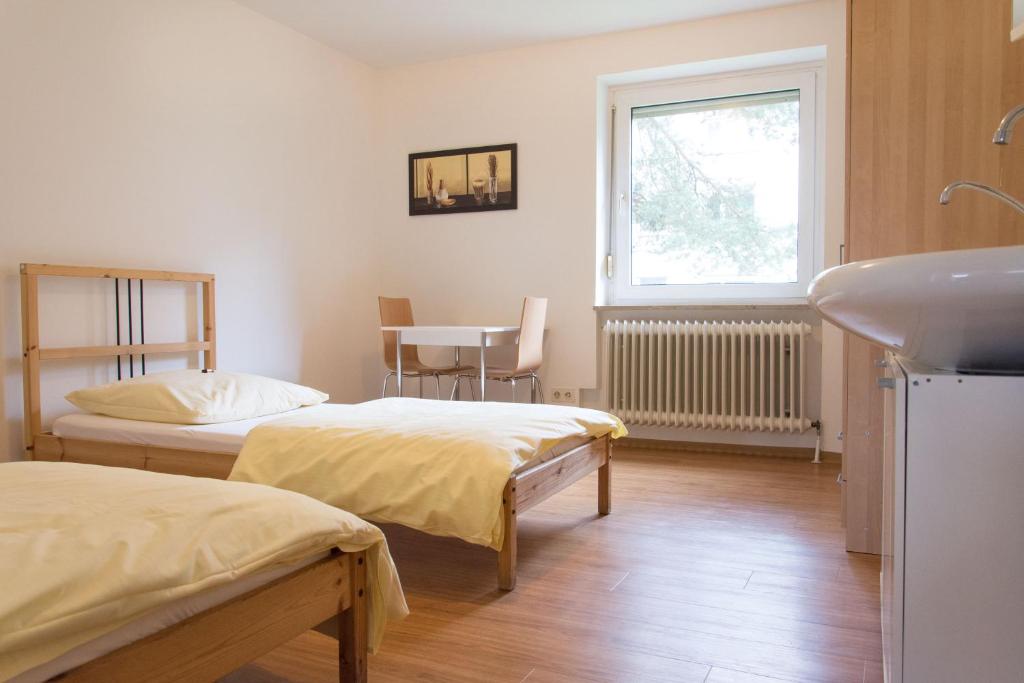 纽伦堡1, 2, sleep Hostel Nürnberg Messe的客房设有两张床、一个水槽和窗户。
