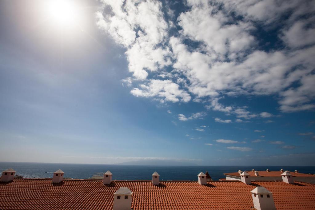 圣地亚哥港Residencial Playa de La Arena的一座建筑的屋顶,以海洋为背景