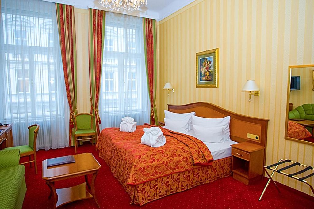 维也纳Pension Opera Suites I Self Check In的酒店客房,配有带两条毛巾的床