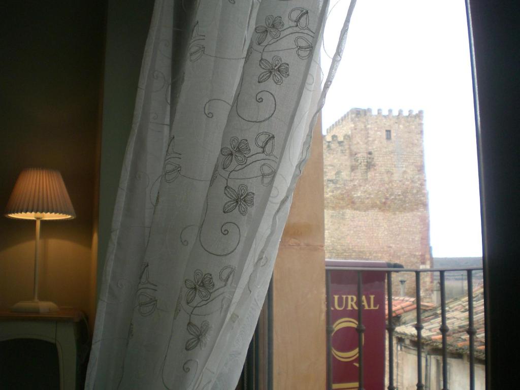 锡古恩萨卡萨卡斯蒂略酒店的窗户配有窗帘,享有城堡的景色