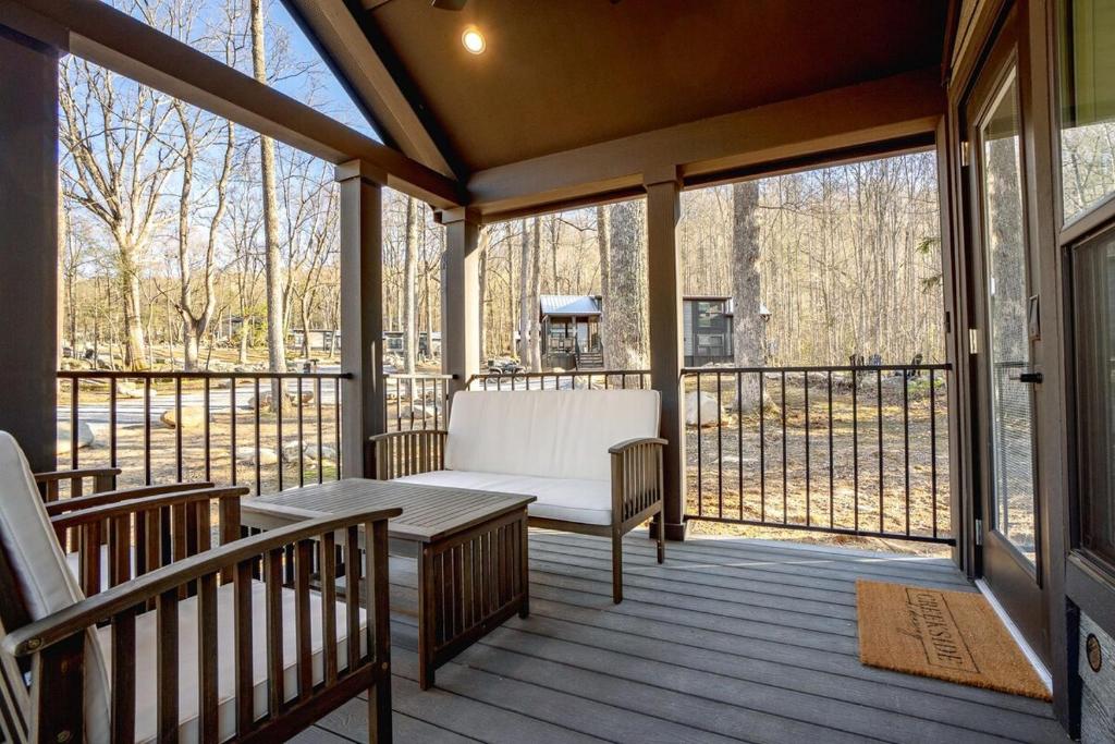 加特林堡Tiny home Fire Pit Fishing Pond BBQ Sage Cabin的一个带长凳和桌子的屏蔽门廊