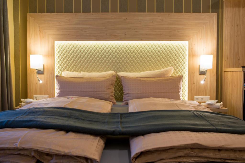 巴特柯尼希祖尔博斯特兰德酒店的卧室内的一张大床,带两个灯