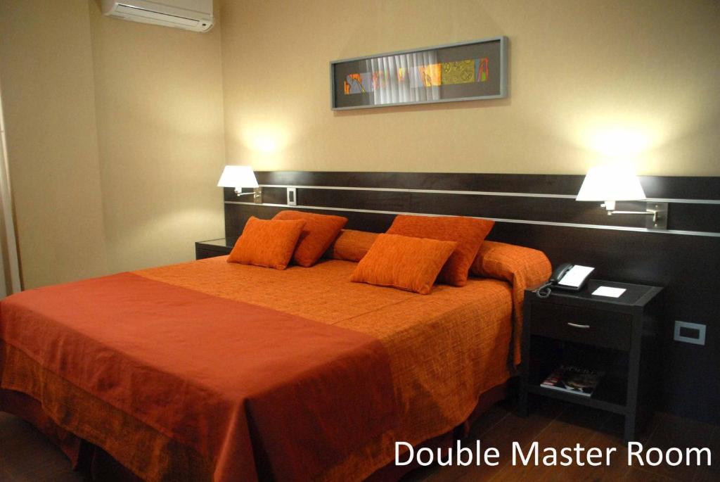 圣米格尔·德·图库玛弗朗西亚酒店的一间卧室配有带橙色床单和枕头的床。