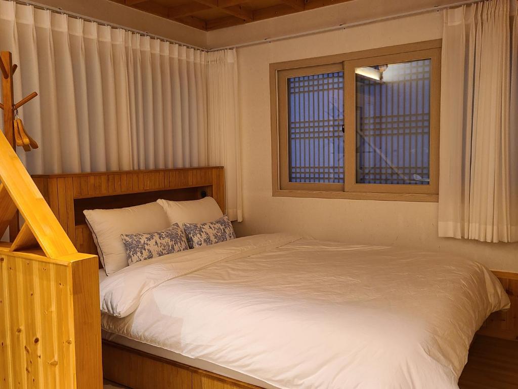 庆州Hanok stay Mokhyang的带一张床和两扇窗户的卧室