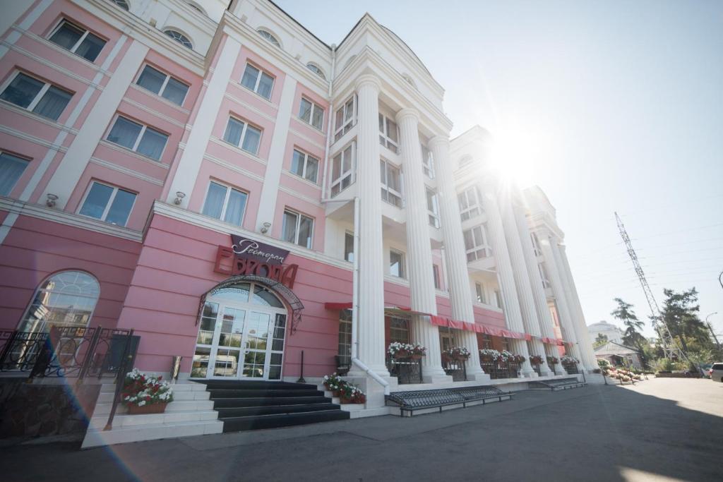 伊尔库茨克欧罗巴酒店的街道上的粉红色和白色建筑