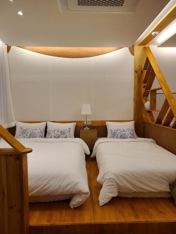 庆州Hanok stay Mokhyang的配有两张单人床的客房,设有楼梯