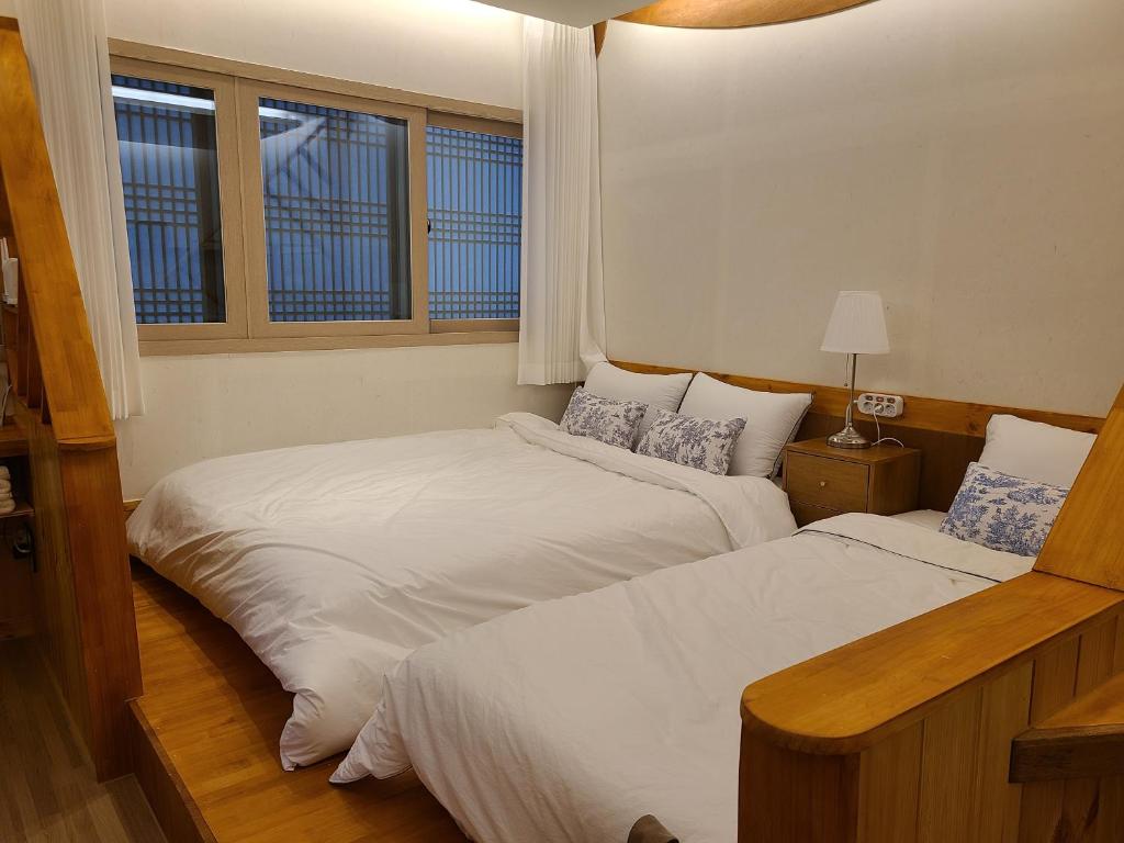 庆州Hanok stay Mokhyang的有两张床的房间有两扇窗户