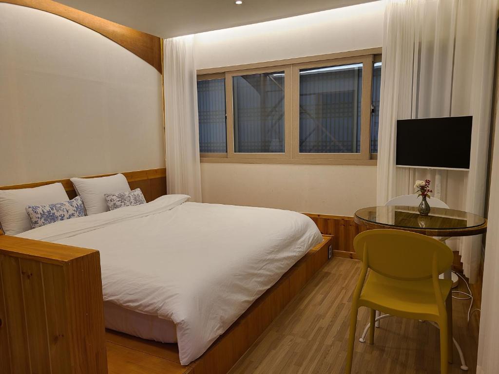 庆州Hanok stay Mokhyang的一间卧室，配有一张床、一张桌子和一台电视机