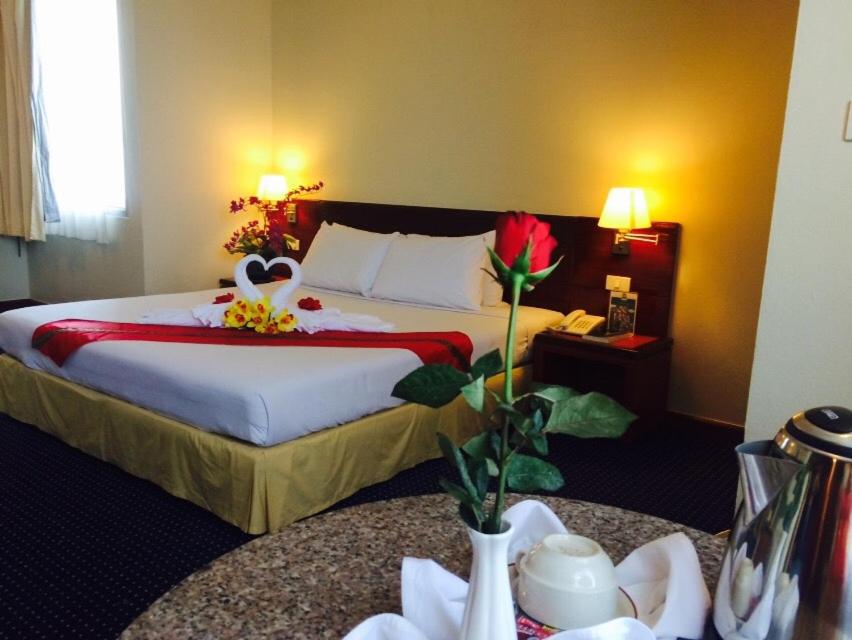 合艾合艾金皇冠酒店的酒店客房,设有一张床和两张桌子