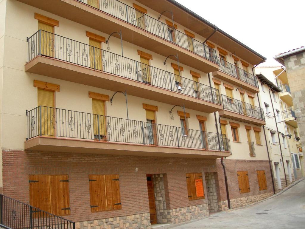 卡马雷纳德拉谢拉Apartamentos Turísticos Rosario的街道上带木制阳台的公寓楼