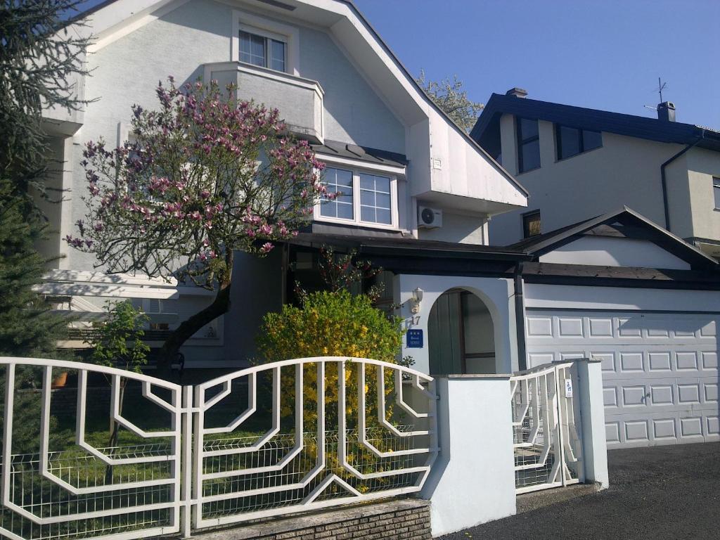 萨莫博尔Apartment & Rooms Miboti的前面有白色围栏的房子