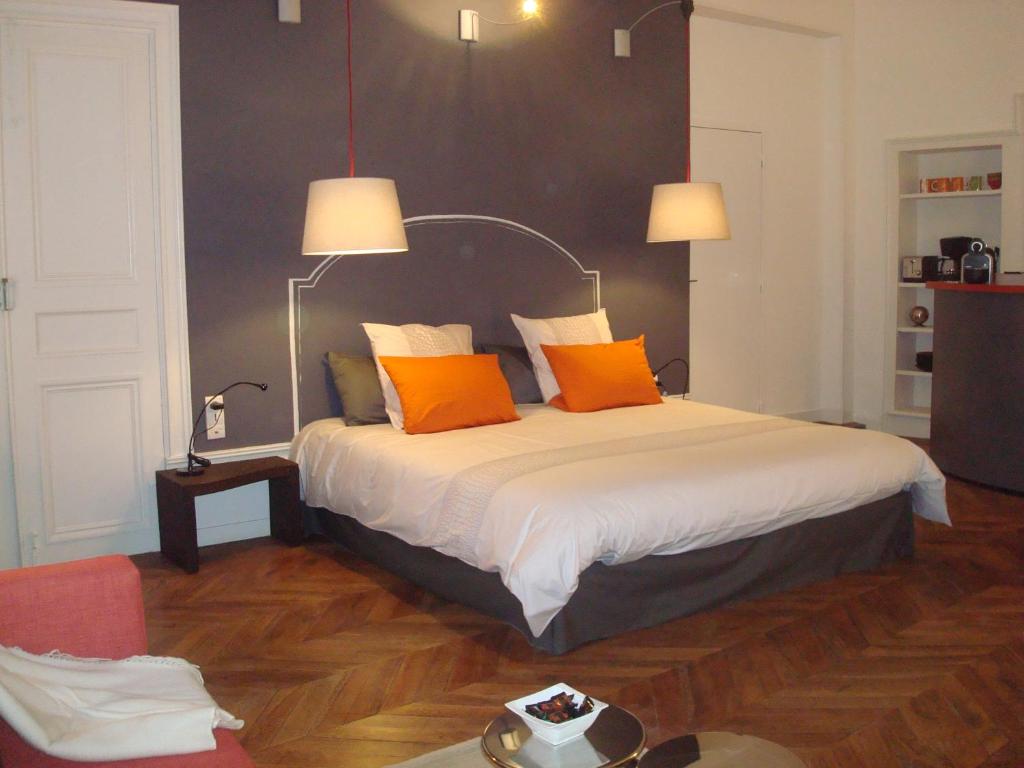 马孔克拉克特尔克劳斯圣简公寓的一间卧室配有带橙色枕头的床