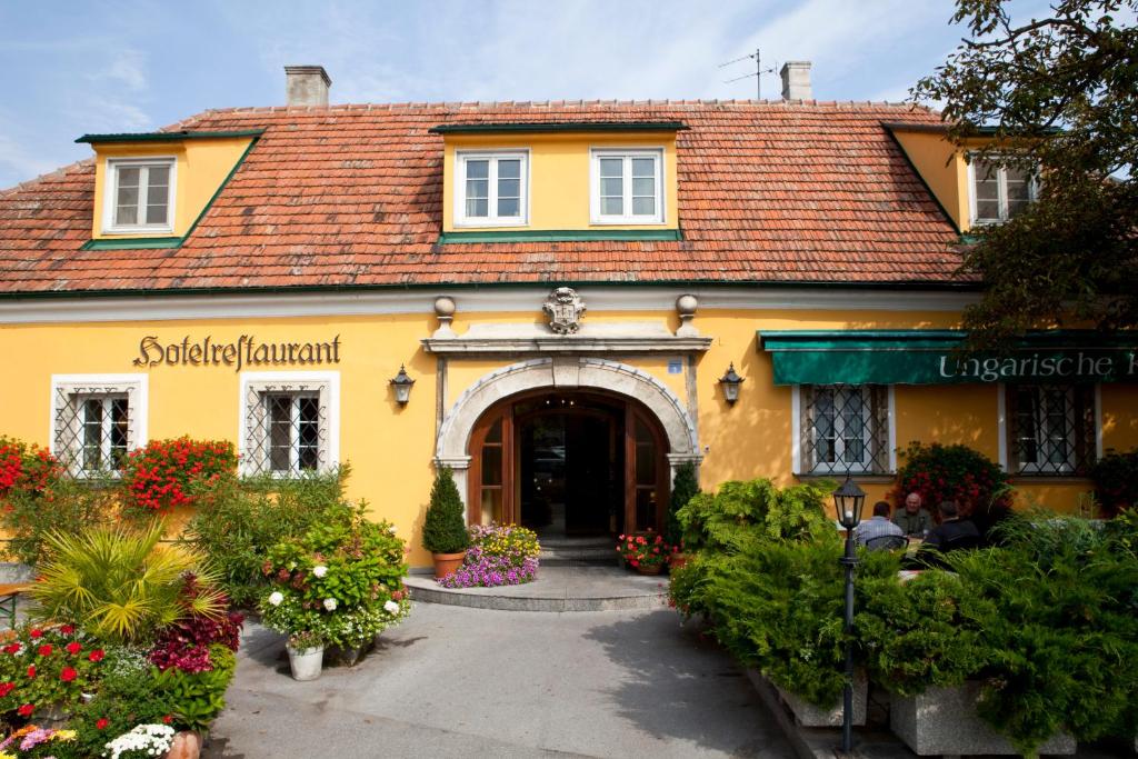 布如克纽多夫匈牙利王冠酒店的黄色的建筑,前面有门和鲜花