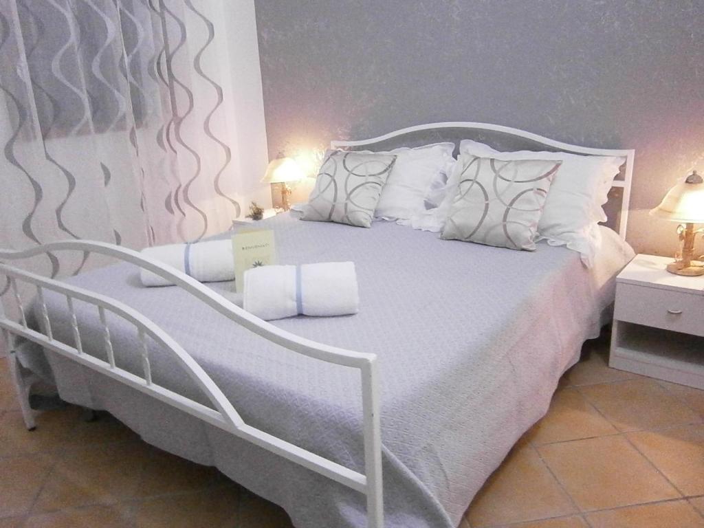 兰佩杜萨B&B La Rosa Lampedusa的卧室配有白色的床铺和白色的枕头