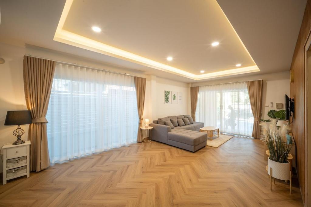 清迈Baan San sook Pool Villa at Nimman的带沙发和大窗户的客厅