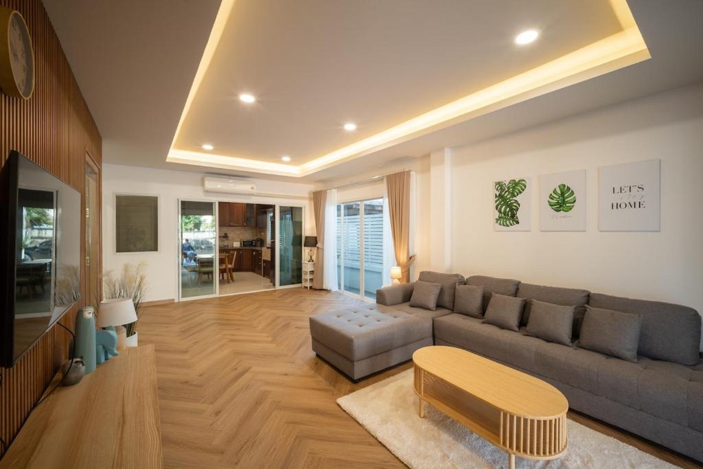 清迈Baan San sook Pool Villa at Nimman的带沙发和桌子的客厅