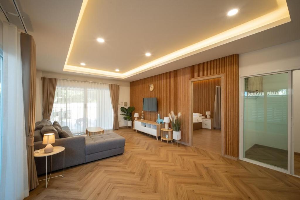 清迈Baan San sook Pool Villa at Nimman的带沙发和桌子的客厅