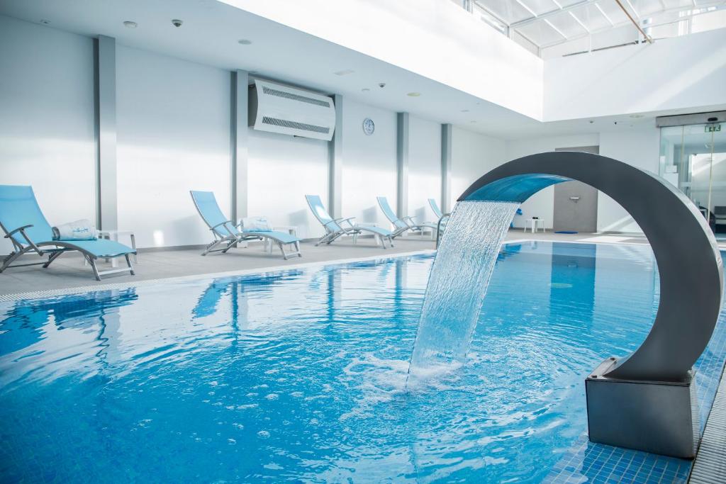 维拉多比斯坡米拉萨格雷斯酒店的一座建筑物内带喷泉的游泳池