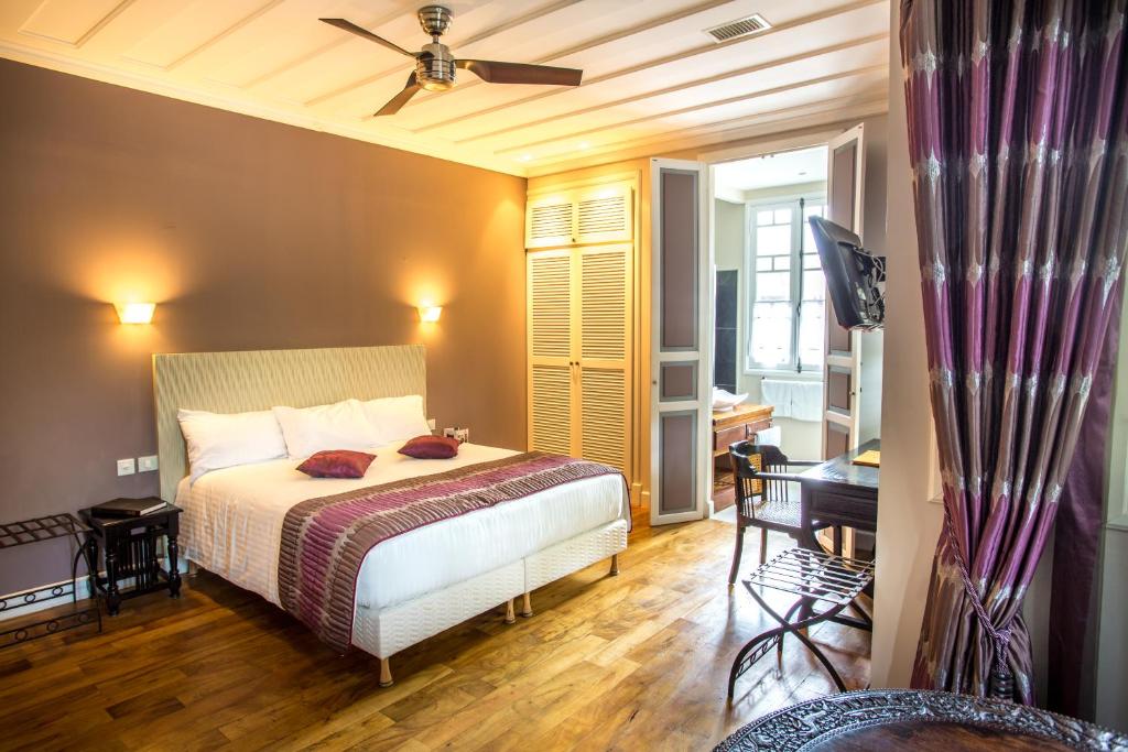 圣丹尼斯Villa Angélique - Hôtel classé Monument Historique的一间卧室配有一张床和吊扇