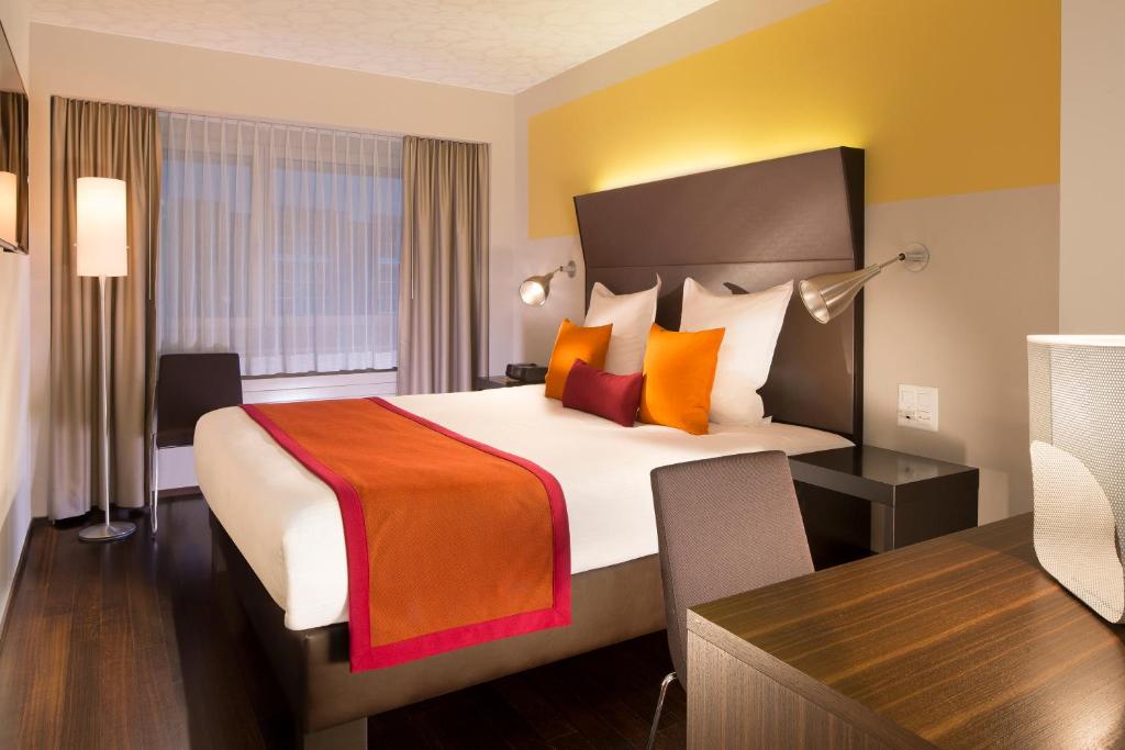 巴塞尔酒店D - 设计酒店的酒店客房设有一张大床和一张书桌。