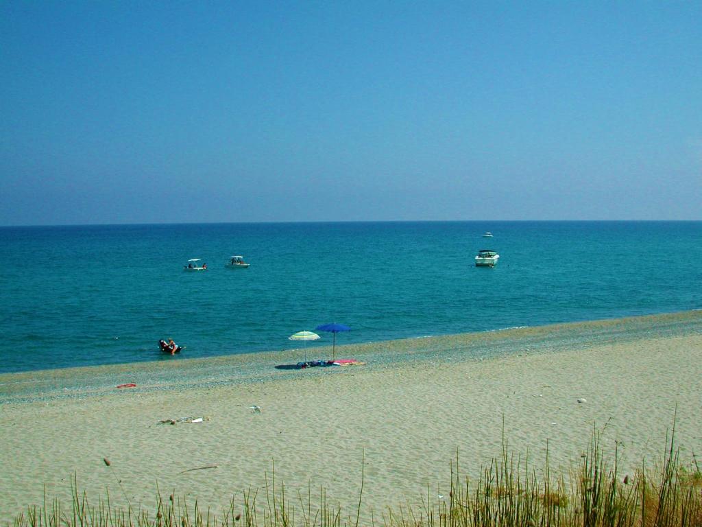 StiloDiving Center Punta Stilo的海滩上设有遮阳伞和船只
