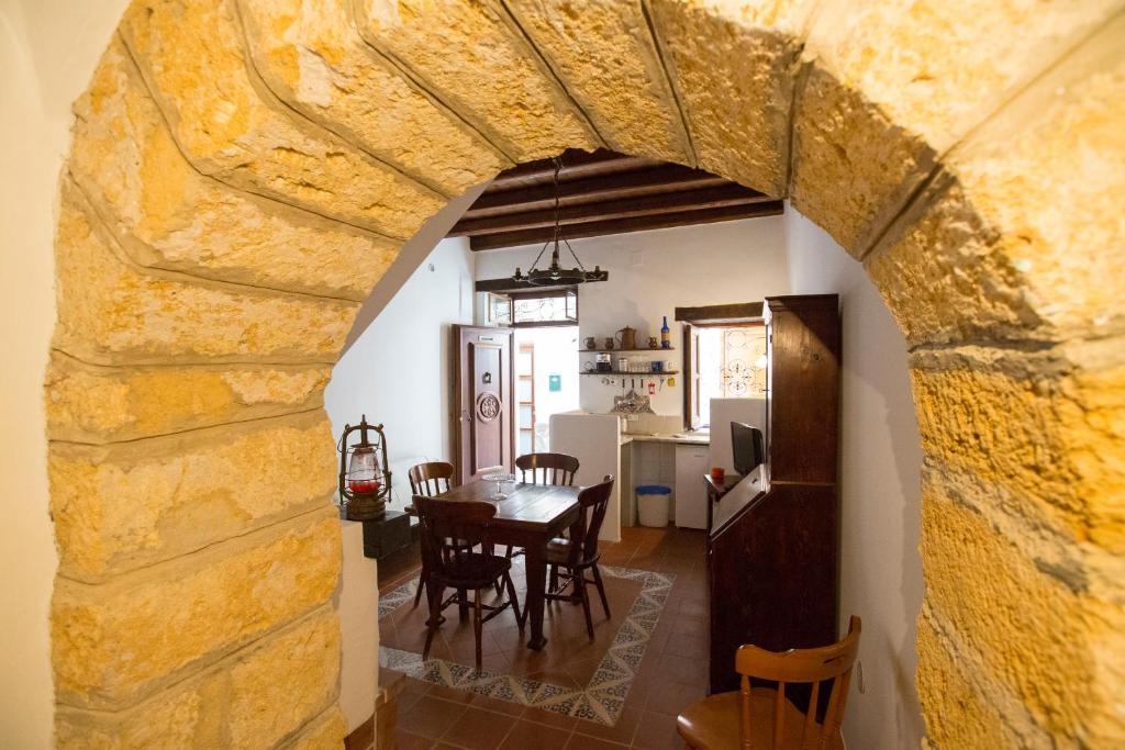 切法卢Bilocale Mandralisca的用餐室和带石墙的厨房