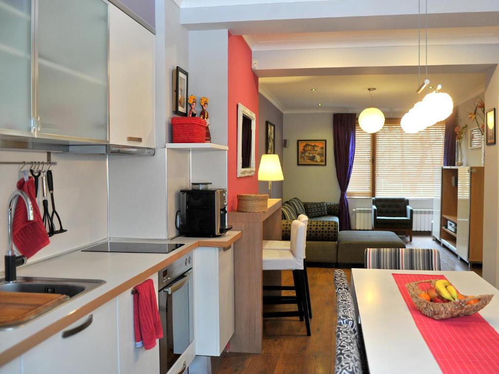索非亚公园美景公寓的厨房以及带沙发和桌子的客厅。